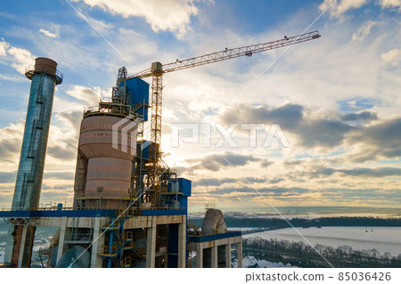 Aerial view of cement plant with high factory structure and tower crane at industrial production area. Aerial view of cement plant with high factory structure and tower crane at industrial production area. 85036426