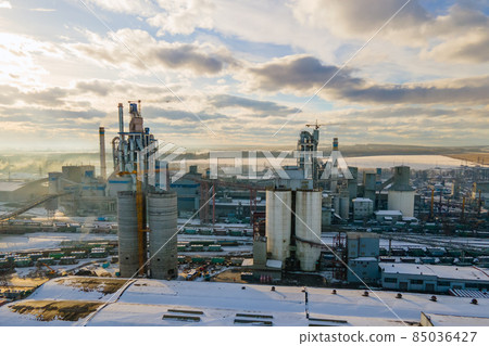 Aerial view of cement plant with high factory structure and tower crane at industrial production area. Aerial view of cement plant with high factory structure and tower crane at industrial production area. 85036427
