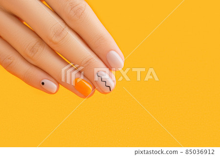 Beautiful womans hand with minimal nail design on orange background. Manicure, pedicure beauty salon concept Beautiful womans hand with minimal nail design on orange background. Manicure, pedicure beauty salon concept 85036912
