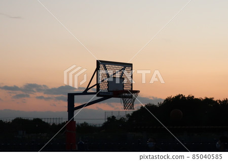 Silhouette of basketball towering over the setting sun Silhouette of basketball towering over the setting sun 85040585