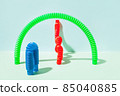 The curved pop tube stands leaning against the wall. Modern still life with antistress toy 85040885