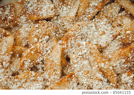 Close up of raw apple pie. Apple wedges sprinkled with nut crumbs 85041135