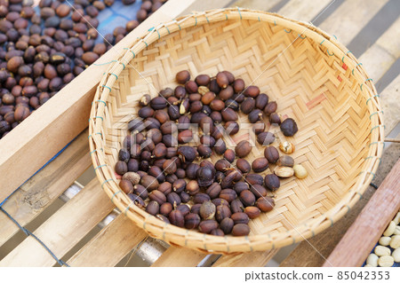 coffee beans Poured on a wooden table, beautifully arranged, decorated with coffee leaves. Is a mixture of raw materials for making coffee 85042353