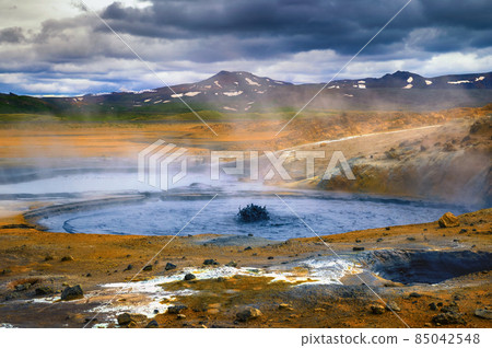 Steaming and bubbling mud pool in the Hverir geothermal area in Iceland 85042548