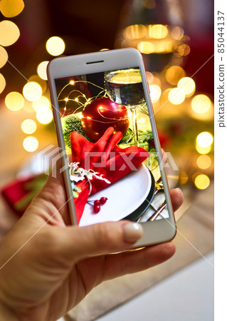 Woman hand is taking pictures on phone the Christmas serving 85044137