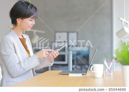 Business woman trying to operate a smartphone 2 85044690