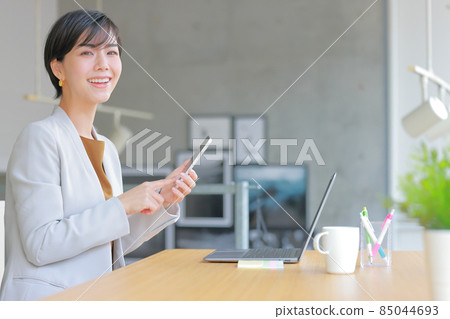 操作智能手機時微笑的女商人 1 85044693