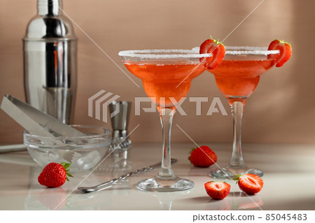 Fresh homemade strawberry margarita cocktails with bar tools on the table. Preparing summer refreshing cocktails Fresh homemade strawberry margarita cocktails with bar tools on the table. Preparing summer refreshing cocktails 85045483