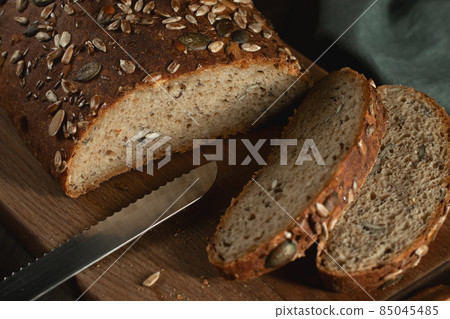Sliced Homemade Whole Grain Bread with Seeds on a Cutting Board, close up Sliced Homemade Whole Grain Bread with Seeds on a Cutting Board, close up 85045485