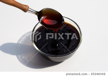 Oyster sauce in glass bowl on white background. Oyster sauce in glass bowl on white background. 85046448