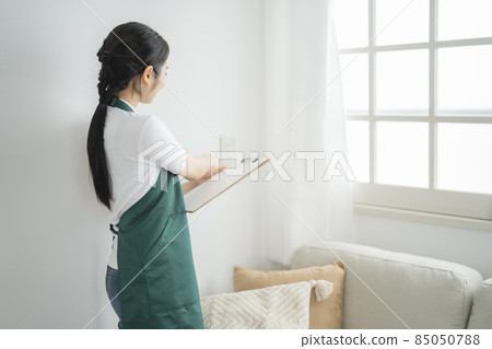 Female checking the power plug outlet 85050788