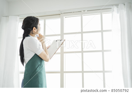 Woman checking the window Woman checking the window 85050792