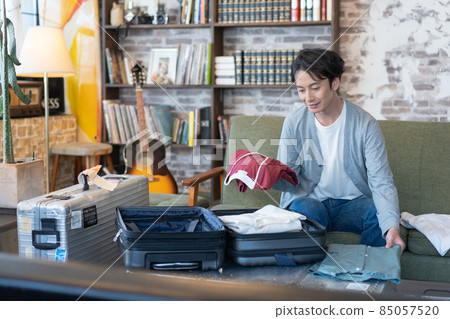 出差，整理，年輕人在客廳的手提箱裡打包衣服 85057520