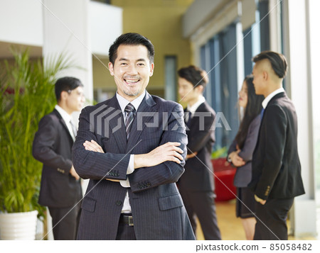 portrait of a senior business manager arms crossed looking at camera with a big smile 85058482