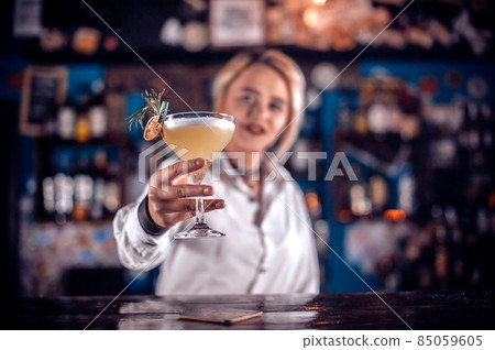 Charismatic girl tapster creates a cocktail on the bar Charismatic girl tapster creates a cocktail on the bar 85059605