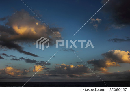 Sunrise clouds floating on the sea, changing colors and shapes as they keep flowing Sunrise clouds floating on the sea, changing colors and shapes as they keep flowing 85060467