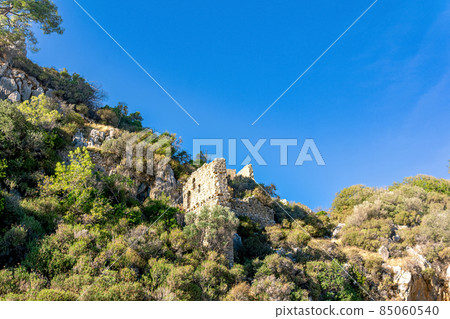 ruins of fortress walls on rocky mountain slopes near the antique city of Olympos, Turkey ruins of fortress walls on rocky mountain slopes near the antique city of Olympos, Turkey 85060540