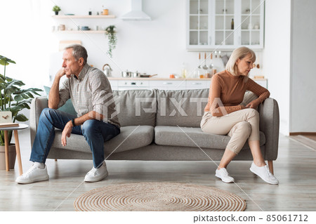 Offended Mature Spouses Sitting Back-To-Back Not Speaking After Quarrel Indoor Offended Mature Spouses Sitting Back-To-Back Not Speaking After Quarrel Indoor 85061712