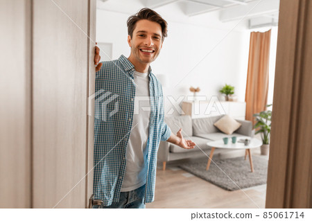 Cheerful guy inviting people to enter home Cheerful guy inviting people to enter home 85061714