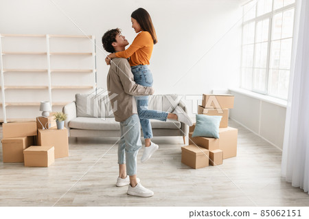 Joyful young Asian couple cuddling while moving to new house, full length. Relocation concept 85062151