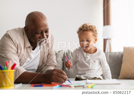African American Grandfather And Little Grandchild Drawing At Home 85062217