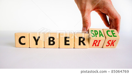 Cyber-space vs cyber-risk symbol. Businessman turns wooden cubes, changes words Cyber-risk to cyber-space. Beautiful white background. Cyber-space vs cyber-risk concept. Copy space. 85064769
