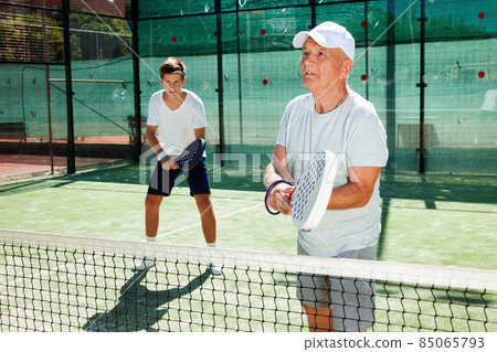 padel players of different generations playing padel court 85065793