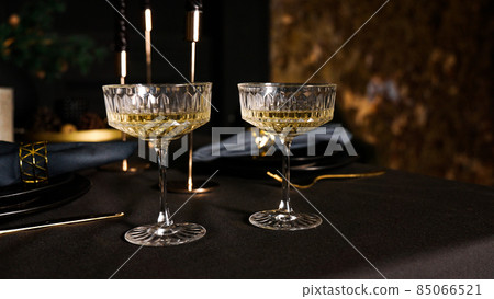 Two popular vintage champagne glasses on a dark background of the served table 85066521