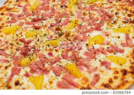 Hawaiian pizza. Close-up of pizza topped with pineapple, ham, cheese and oregano. Hawaiian pizza. Close-up of pizza topped with pineapple, ham, cheese and oregano. 85066764