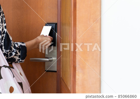 Woman's open hotel room with electronic key card. Woman's open hotel room with electronic key card. 85066860