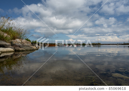 A blue sky with patchy clouds over a calm bay in summertime. From the swedish island oland. 85069618