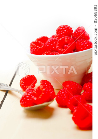 bunch of fresh raspberry on a bowl and white table bunch of fresh raspberry on a bowl and white table 85069893