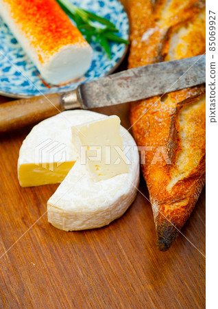 French cheese and fresh  baguette on a wood cutter 85069927