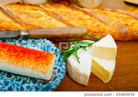 French cheese and fresh baguette on a wood cutter French cheese and fresh baguette on a wood cutter 85069936