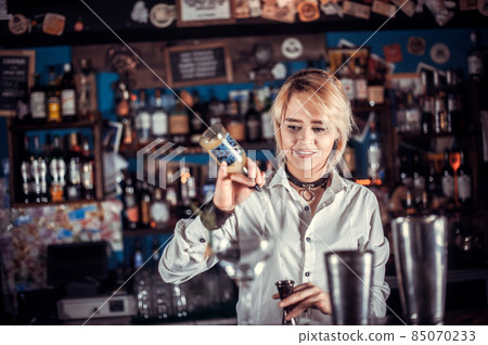 Girl bartender concocts a cocktail on the porterhouse Girl bartender concocts a cocktail on the porterhouse 85070233