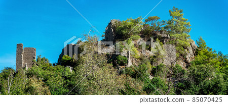 ruins of fortress walls on wooded mountain slopes in the antique city of Olympos, Turkey 85070425