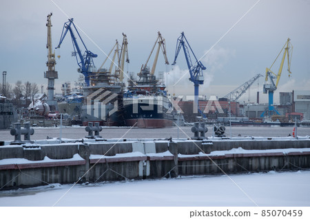 The construction of nuclear icebreakers, cranes of of the Baltic shipyard in a frosty winter day, steam over the Neva river, smooth surface of the river The construction of nuclear icebreakers, cranes of of the Baltic shipyard in a frosty winter day, steam over the Neva river, smooth surface of the river 85070459