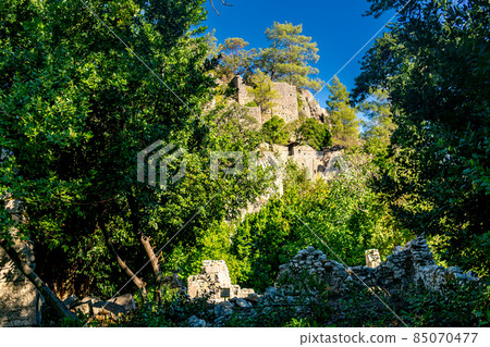 ruins of fortress walls on wooded mountain slopes in the antique city of Olympos, Turkey ruins of fortress walls on wooded mountain slopes in the antique city of Olympos, Turkey 85070477