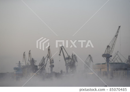 The construction of nuclear icebreakers, cranes of of the Baltic shipyard in a frosty winter day, steam over the Neva river, smooth surface of the river The construction of nuclear icebreakers, cranes of of the Baltic shipyard in a frosty winter day, steam over the Neva river, smooth surface of the river 85070485