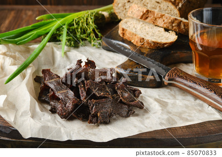 Heap of jerky venison on wrapping paper 85070833