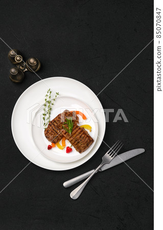 Two grilled steaks on a plate 85070847