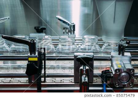 pharmaceutical industry, medicine pills are filling in the plastic bottle on production line machine conveyor at the medical factory. selective focus and film style. 85075479