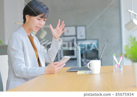 A business woman with a rugged expression when a phone call comes from an unpleasant number 2 A business woman with a rugged expression when a phone call comes from an unpleasant number 2 85075934