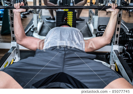 Image of the pectoral muscles of a cool bodybuilder (trainee) training with a barbell 85077745