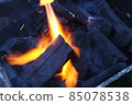 Fire on logs in fire pot with embers and burning coal and blazing flames. 85078538