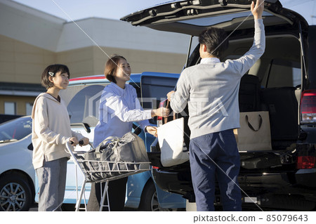 Family image of putting products purchased at a supermarket in a car 85079643