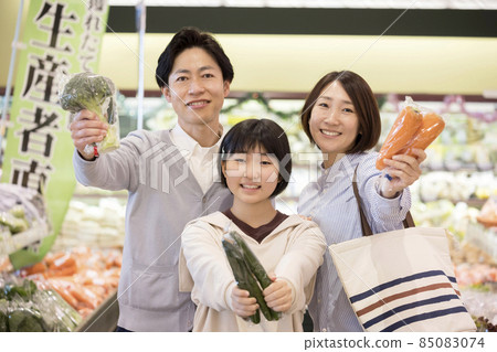Parents and children offering vegetables at the supermarket Parents and children offering vegetables at the supermarket 85083074