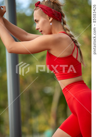 Beautiful young caucasian woman in fitness wear doing exercises in a park Beautiful young caucasian woman in fitness wear doing exercises in a park 85083426