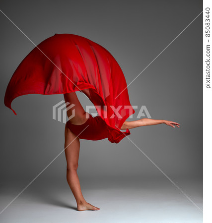 Ballerina Jumping in Pointe Shoes with Flying Red Cloth, Modern Ballet Dance, Isolated Gray Background Ballerina Jumping in Pointe Shoes with Flying Red Cloth, Modern Ballet Dance, Isolated Gray Background 85083440