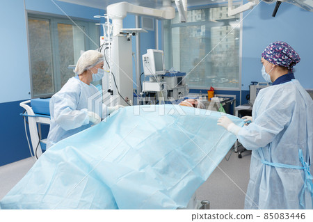 Concentrated Surgical team operating a patient in an operation theater Concentrated Surgical team operating a patient in an operation theater 85083446